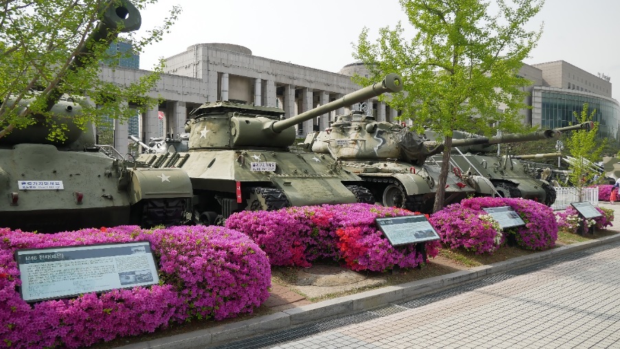 kontrast tanků a kvetoucích azalek u War Memorial v Seoulu