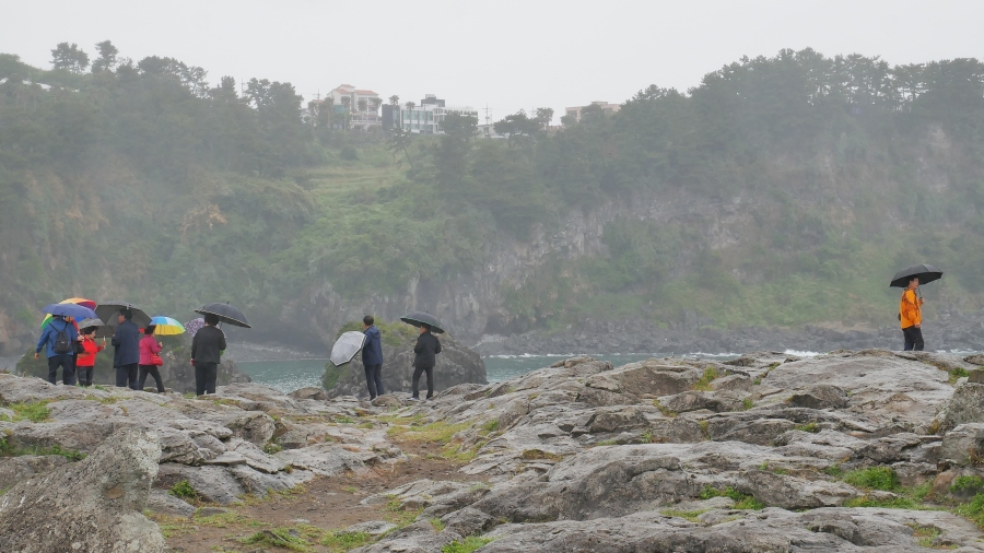 ani deštivé počasí neodradí Korejce od hikingu po jižním pobřeží Jeju
