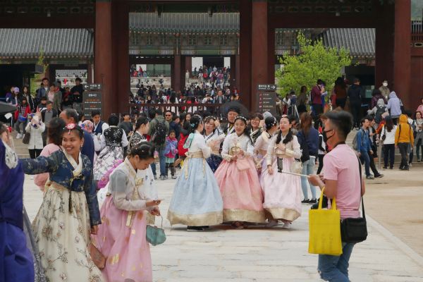 Návštěvníci palácového komplexu v tradičních šatech hanbok.