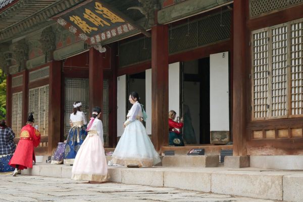 Návštěvníci v šatech hanbok v palácových zahradách Changgyeonggung.